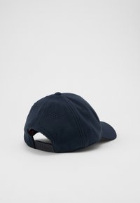 Marineblaue Mütze mit einem weichen, strukturierten Fleece-Rücken, einem gebogenen Schirm und einem verstellbaren Plastikband mit eingeprägtem "HUGO".
