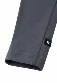 Szara dzianina polarowa o gładkiej fakturze, z czarną metką z białym logo "R" na dole. Projekt charakteryzuje się prostym, czystym wykończeniem.