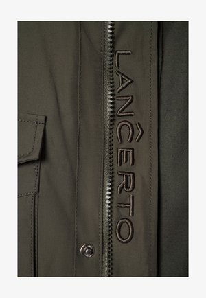 Ciemnozielona, trwała kurtka z widocznym zapięciem na zamek, wyszywane logo "LANCERTO", kieszeń boczna i gładka faktura.