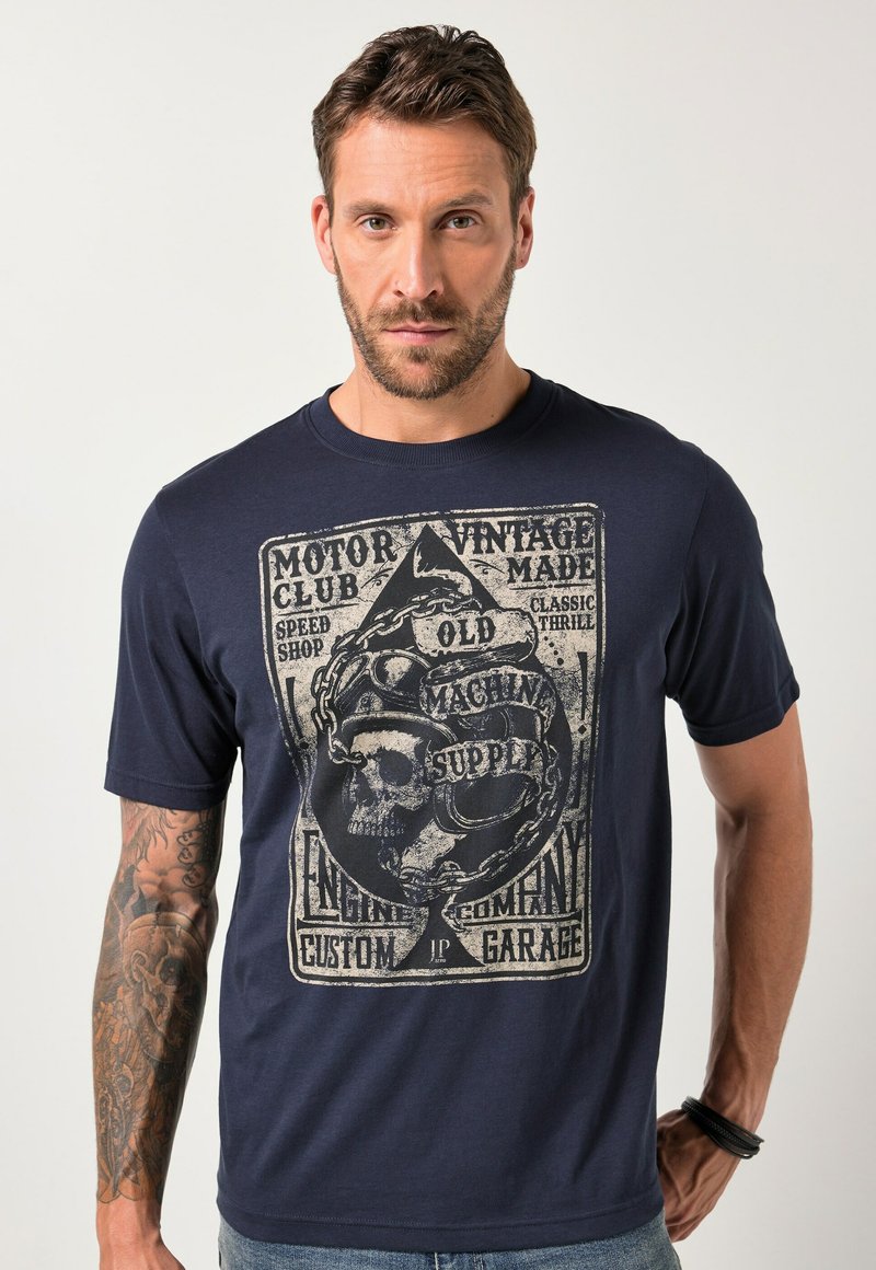 Tmavě modré tričko z bavlny s vintage grafikou lebky a motocyklu v světle béžové barvě na přední straně. Krátké rukávy, kulatý výstřih.