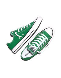 Par zelene nizke Converse superge z belimi vezalkami, gumijastimi podplati in črnim črtastim vzorcem na belem ozadju.