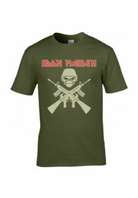 Camiseta de algodón verde oliva con un diseño central de un cráneo con casco, flanqueado por rifles cruzados y el texto "IRON MAIDEN" en rojo.