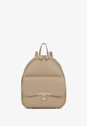 Zaino in pelle beige con forma arrotondata, chiusura con doppia cerniera, tasca frontale con patta e accenti metallici. Texture liscia. Due manici superiori.