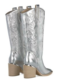 Silver cowboy boots with a shiny leather finish, embossed floral designs, and a chunky wooden heel. Features pull loops for easy wear.