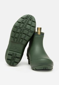 Zielone gumowe botki za kostkę z teksturowaną podeszwą, elastycznymi panelami bocznymi oraz pętlą do łatwego zakładania. Gładka powierzchnia o matowym wykończeniu.
