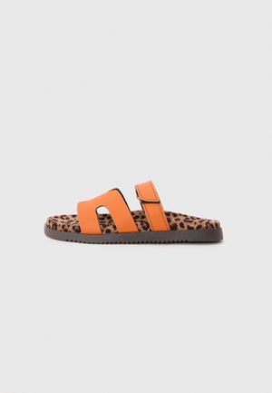 Orange slide sandaler med to brede stropper, med en leopardmønstret indersål og tekstureret sål for grep. Enkelt design, uformell stil.