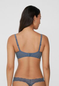 Blaue Spitzen-BH mit verstellbaren Trägern und Hakenverschluss. Blumenmuster über den gesamten Stoff, mit passendem Spitzen-Tanga sichtbar.