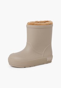 Bota de goma color caqui con punta redondeada, suela texturizada y forro de pelaje sintético en la parte superior. Presenta un pequeño logotipo de la marca en el costado.