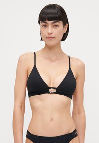 Zwarte bikini top met een driehoekig ontwerp, dunne bandjes en uitsnijdingen aan de voorkant. Gemaakt van gladde stof, met een kleine logo-accent.