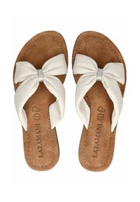 Sandales blanches en cuir à enfiler avec un grand nœud décoratif, semelle intérieure en suède beige et bords cousus. Présente des éléments en métal argenté au centre du nœud.