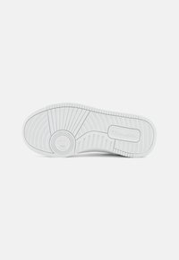 Semelle de basket blanche avec des rainures et motifs texturés, présentant une zone de logo circulaire et un design de semelle distinct pour une meilleure traction.