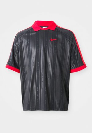 Black short-sleeve polo shirt with red collar and cuffs, subtle vertical stripes with "Nike" text, and red Nike swoosh logo on chest.