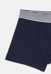 Marineblauwe katoenen boxershorts met een zwart-wit gestreepte elastieken tailleband, weergegeven op een effen witte achtergrond.