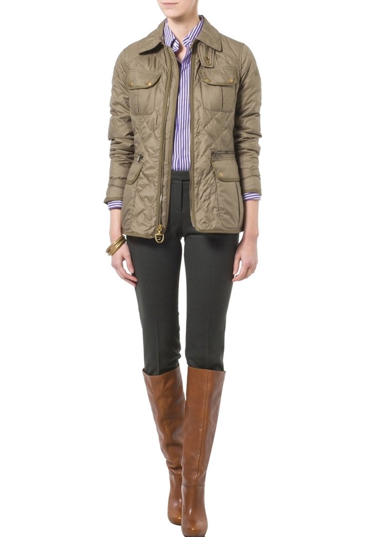 Quiltad olivgrön jacka med två bröstfickor, i kombination med mörkgröna byxor och bruna knä-långa stövlar. Har en dragkedja och tryckknappsstängning.