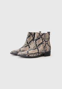 Botines de serpiente con un patrón en beige y negro, textura suave, punta afilada y tacón corto en bloque; incluyen cierre de cremallera en el lateral.