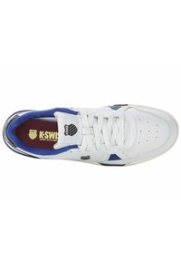 Sneaker bianco in pelle con accenti blu, punta perforata, lacci bianchi, colletto imbottito e logo di lato. Soletta in tessuto morbido visibile.