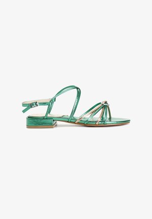 Groene metallic sandalen met een blokhak, voorzien van dunne kruisende banden en een decoratieve accenten aan de voorkant. Verstelbare enkelband.