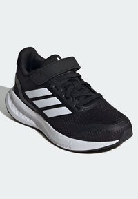 Scarpa sportiva nera con tomaia in rete, accenti bianchi, collare imbottito e cinturino regolabile, dotata di un intersuola Cloudfoam ammortizzata.