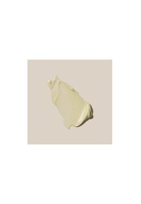 Crème beige clair étalée de manière uniforme sur un fond pâle, avec une texture légèrement brillante et un subtil grain visible par endroits.