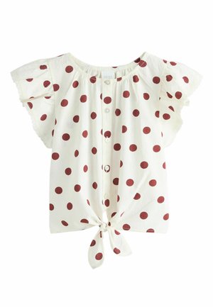 Fehér rövid ujjú blúz nagy piros pöttyökkel, gombos elől, fodros ujjak és megkötött csomó az alsó szegélyén.