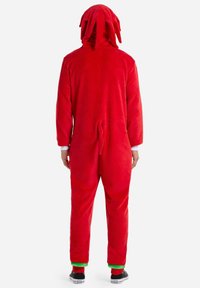 Red, fleece onesie with a hood featuring pointed accents. Includes a tail-like detail and green cuffs at the wrists and ankles.