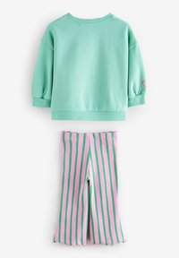 Miętowy, krótki sweatshirt z bufiastymi rękawami i małym różowym serduszkiem. Różowo-zielone legginsy w paski z falbaniastym dołem.