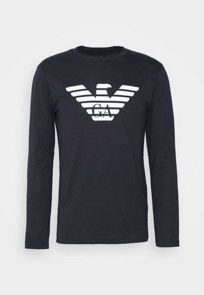 T-shirt de manga longa azul-marinho feito de algodão, apresentando um logotipo de águia branca com design riscado no peito, gola redonda e mangas ajustadas.