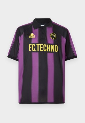 Violetti ja musta pikeepaita pystysuorilla raidoilla, jossa on musta kaulus, Kappa-logo ja "F.C.TECHNO" paksulla keltaisella painatuksella.