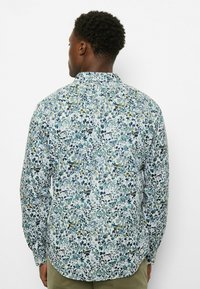 Langärmliges Hemd mit hellblauem Hintergrund und dichtem Blumenmuster in Grün-, Marine- und Gelbtönen. Klassischer Kragen und normale Passform.