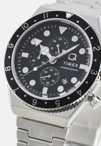 Orologio cronografo Timex con quadrante nero, cinturino in acciaio inossidabile argento, indici luminescenti e lunetta rotante nera. Include sottodial.