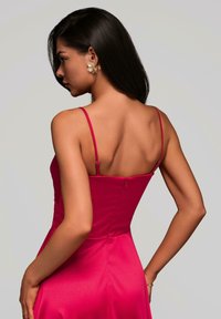 Tailliertes pinkes Satin-Kleid mit dünnen Trägern, ausgestattet mit einem Reißverschluss an der Rückseite und einer glatten Textur, die eine elegante Silhouette betont.