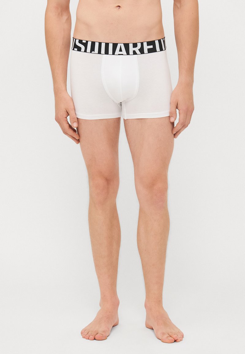 White boxer shorts with a black elastic waistband featuring the text "SQUARED." Made of soft fabric, fitted design with a smooth texture.