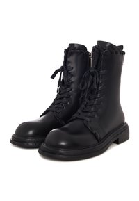 Paire de bottes de combat en cuir noir avec lacets et fermetures éclair latérales, présentant des détails de surpiqûres autour du haut et des panneaux avant.