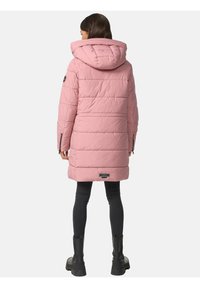 Garšs, gaiši rozā pūšamais žakets ar kapuci, ar kvadrāta šuvēm un logotipa uzšuvi kreisajā piedurknē. Redzamas melnas kabatas ar rāvējslēdzējiem.