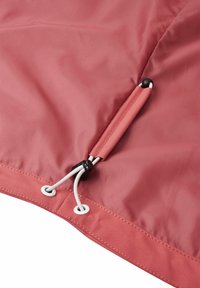 Tissu rouge avec des cordons blancs réglables passés à travers des œillets métalliques et un cordon noir en plastique pour le serrer.