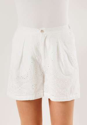 Pantaloni shorts bianchi in cotone con motivo a broderie anglaise, caratterizzati da tagli intricati, chiusura con bottone e design plissettato sul davanti.