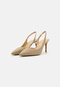 Pointed-toe slingback heels in metallic gold fabric, featuring a slender heel, textured surface, and open back design.