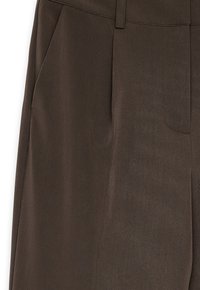 Bruine broek van gladde stof, met een goed passende snit, zijzakken en een schone voorkant met een subtiele structuur.