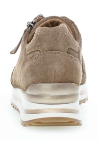 Suède sneaker in lichtbruin, met een ronde vorm, gevoerd kraagje en een witte tussenzool met een doorzichtige sectie. Ritsdetail aan de bovenkant.