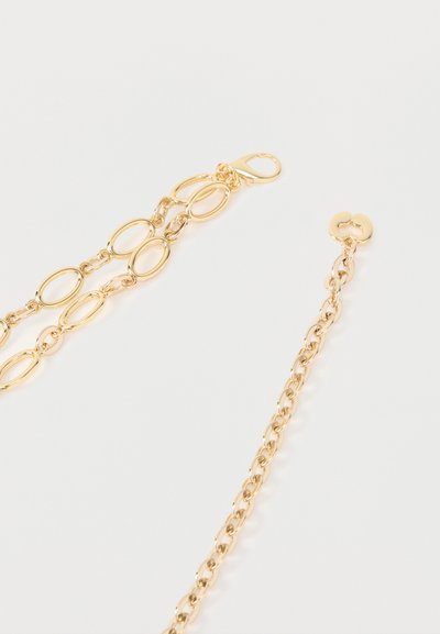 Δύο τμήματα αλυσίδας σε χρυσό τόνο, το ένα με οβάλ κρίκους και κούμπωμα σε σχήμα αστακού, το άλλο με μικρότερους στρογγυλούς κρίκους και καρδιόσχημο τελείωμα.