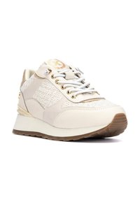 Zapatillas color beige que combinan un tejido texturizado con cuero suave, detalles en dorado y una suela acolchada para mayor comodidad.