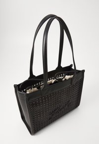 Juoda pintinė pirkinių maišelis su odiniais akcentais, dviem rankenėlėmis ir lengvu audiniu pamušalu. Turi struktūruotą formą ir ryškų prekės ženklą.