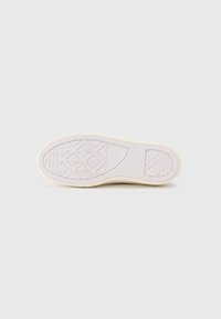 Talpa unei adidași; material din cauciuc de culoare crem cu o suprafață texturată. Modelul include forme de diamante și striații pentru aderență.