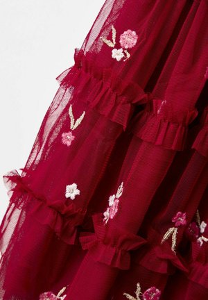 Țesătură transparentă de un roșu intens, cu straturi plisate și mici flori brodate roz și albe, precum și frunze răspândite pe întreaga suprafață.