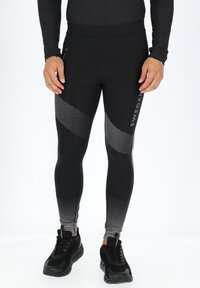 Zwarte sportleggings met een gestippeld patroon en een zijzak met rits. Gemaakt van een gladde, rekbare stof voor optimaal comfort.