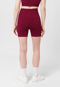 Bordeauxkleurige, aansluitende shorts met een hoge taille, gemaakt van rekbaar materiaal. Heeft een gladde textuur en minimale naaddetails.