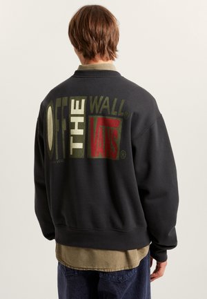 Felpa nera con grande testo grafico stampato sul retro in rosso e verde. Collo rotondo, spalle scese e polsini a coste con texture morbida.