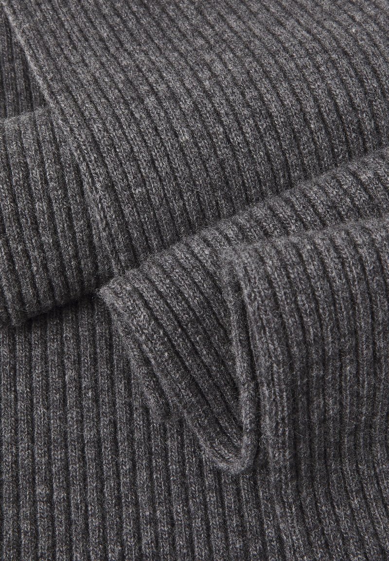Gray knit fabric with a ribbed texture, featuring soft, fuzzy fibers. Rolled edges reveal layered folds, creating depth and dimension.