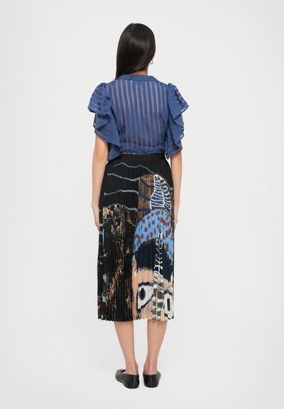 Blue striped blouse with ruffled sleeves, paired with a pleated black skirt featuring a colorful abstract pattern. Black flat shoes.