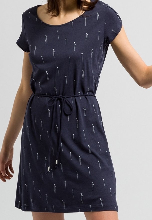 Granatowa sukienka z krótkim rękawem, uszyta z miękkiego materiału, z wiązaniem w talii i powtarzającym się wzorem białych strzałek.